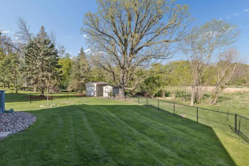 Fully fenced in backyard abuts a marsh area full of wildlife.