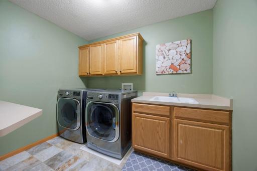 The conveniently located upper-level laundry room with built-in cabinetry adds ease and practicality to daily living.