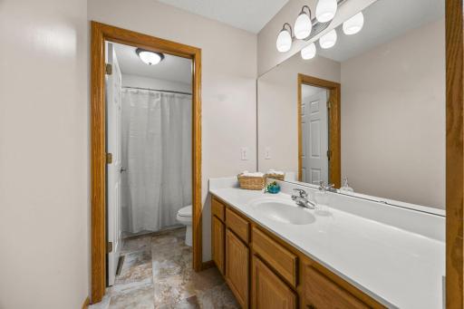 Just steps from the upper-level bedrooms is a shared full bathroom featuring a spacious single vanity and a separate water closet with a tub and shower combination.