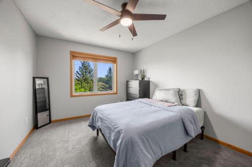 Bedroom two features carpeting, a ceiling fan, and generous closet space.
