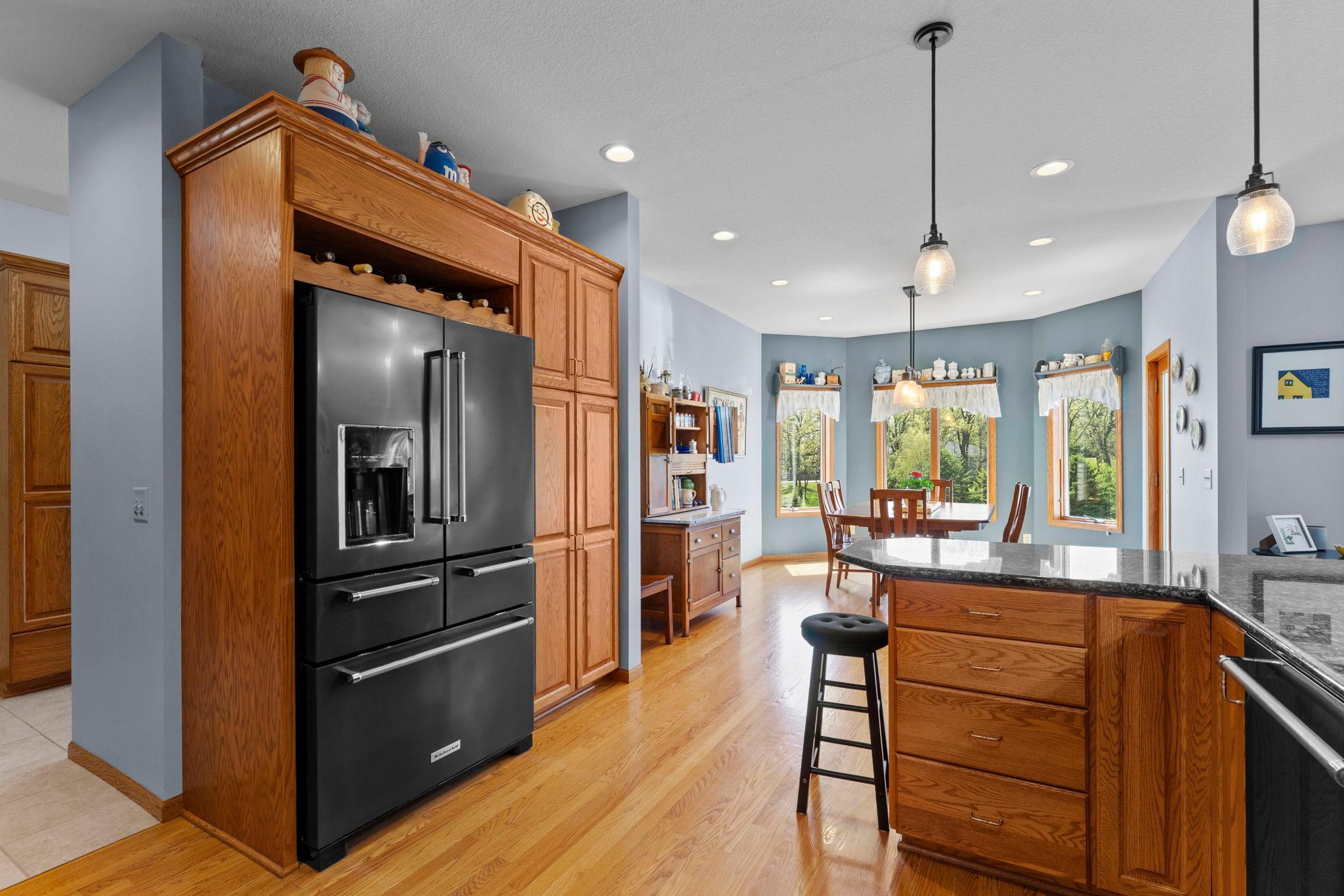 The open flow into the dining room is complemented by expansive cabinetry and a generous pantry