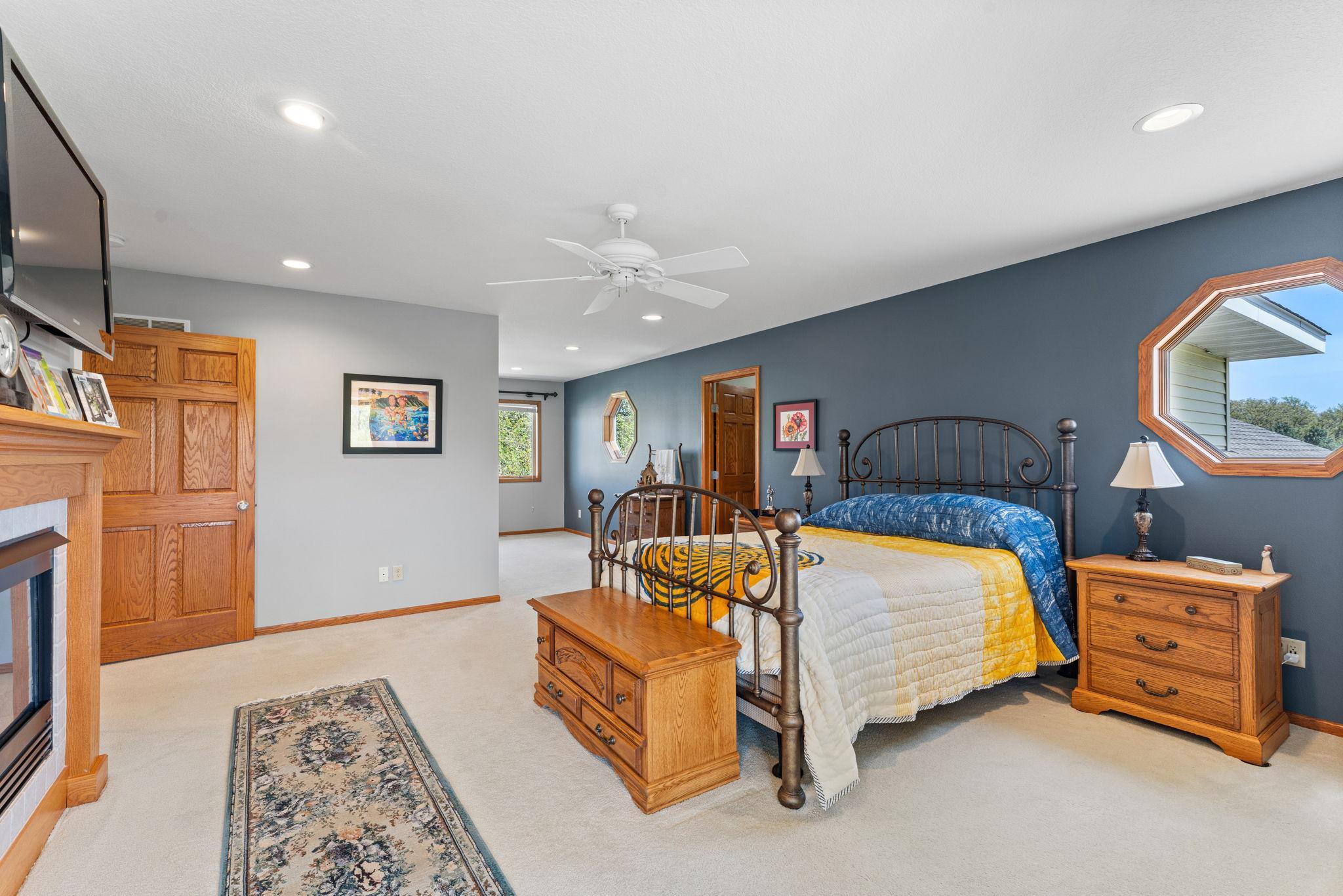 The expansive primary suite features a sitting area with lovely views of the front yard.