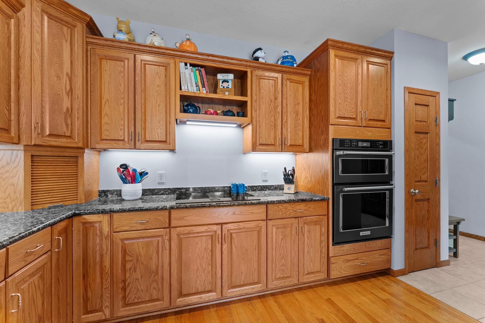 The chef's kitchen is appointed with stainless steel appliances and under-cabinet lighting.