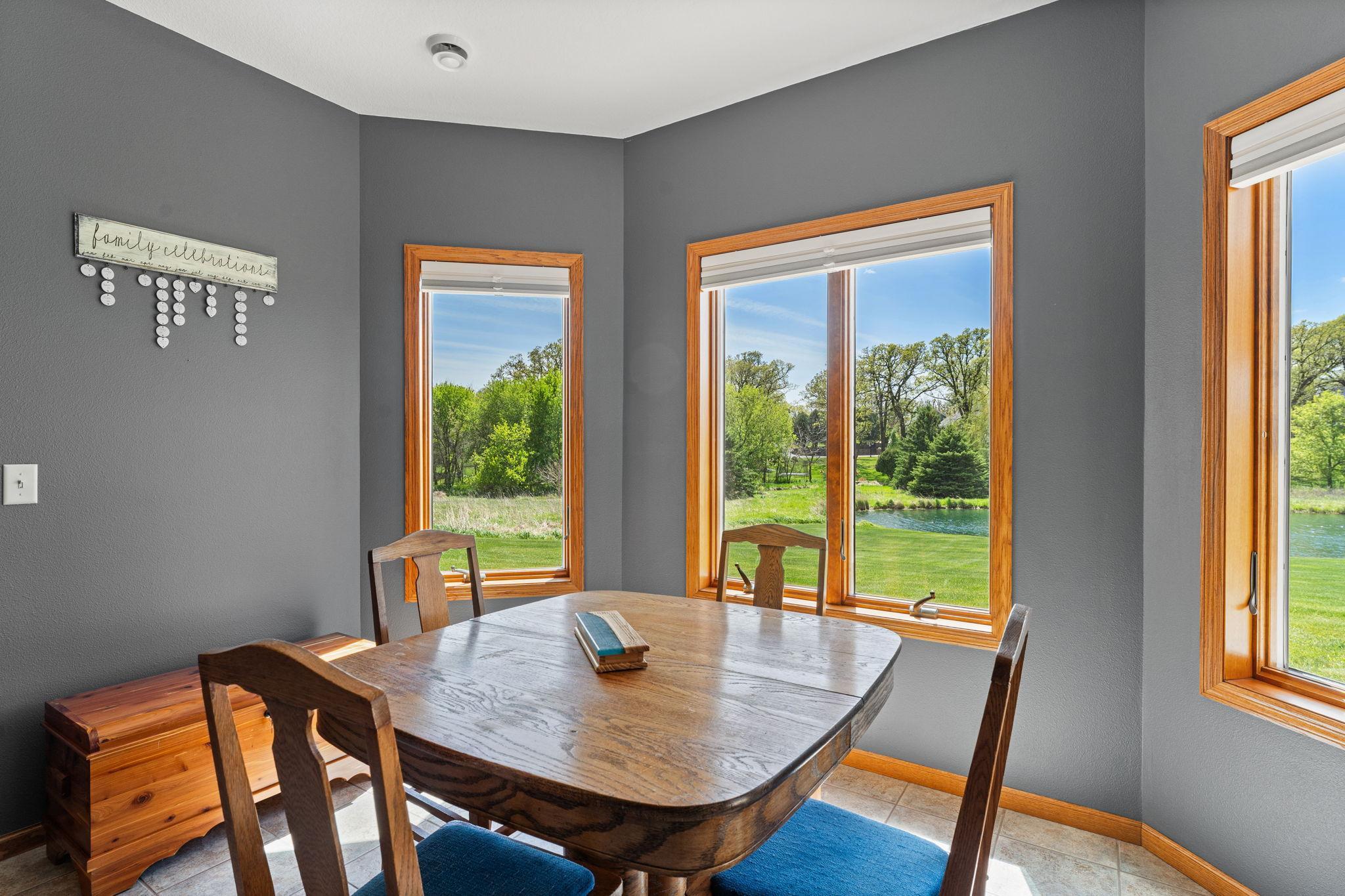 A walkout opens to a spacious patio, while a light-filled alcove offers flexible space for games, sitting, or hobbies