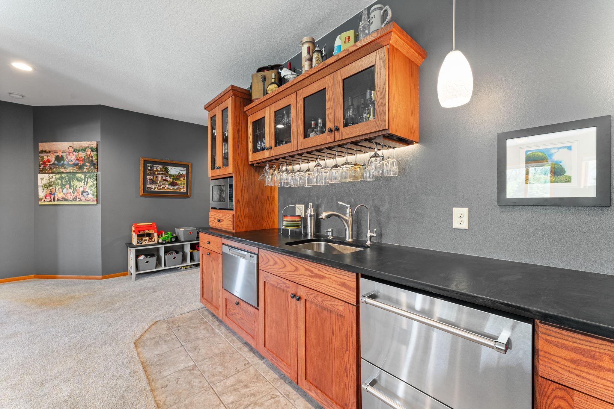 A fully equipped bar includes a refrigerator, freezer, microwave, dishwasher, and bar sink.