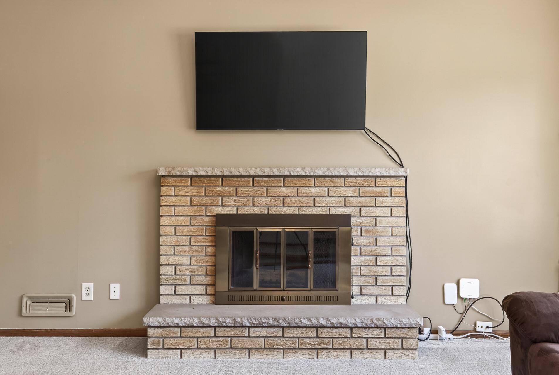 Cozy brick fireplace creates a warm gathering space