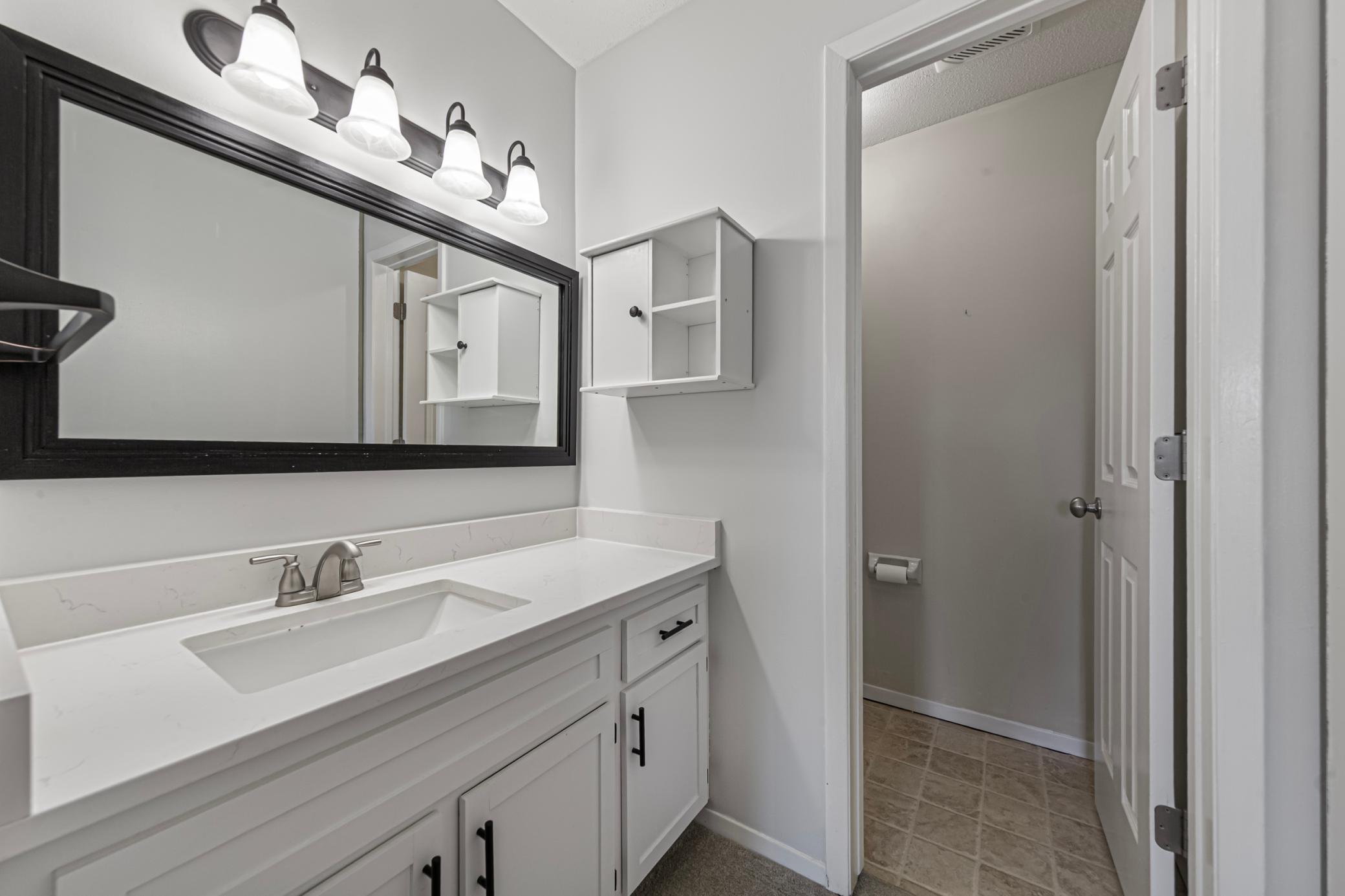 Primary bedroom private 1/2 bathroom with updated vanity area.