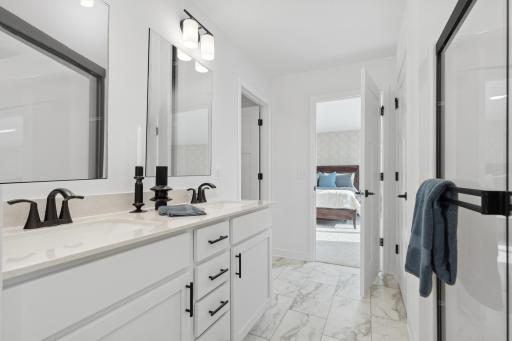 Photo is of the actual model. An extension of the primary suite, this private and spacious bath contains a double-vanity, a separate shower, and a walk-in closet.