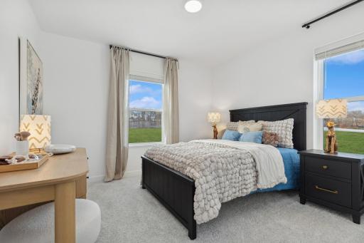 Photo is of the actual model. One of the three generously sized upper level secondary bedroom with a spacious closet.
