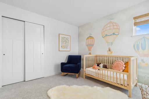 Photo is of the actual model. One of the three generously sized upper level secondary bedroom with a spacious closet.