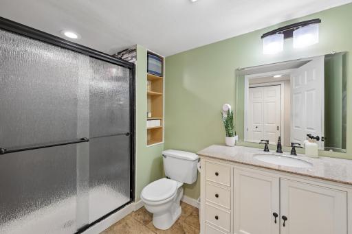 The downstairs bathroom has been updated to a sleek black channeled shower door, new tile, vanity, light fixture, and hardware