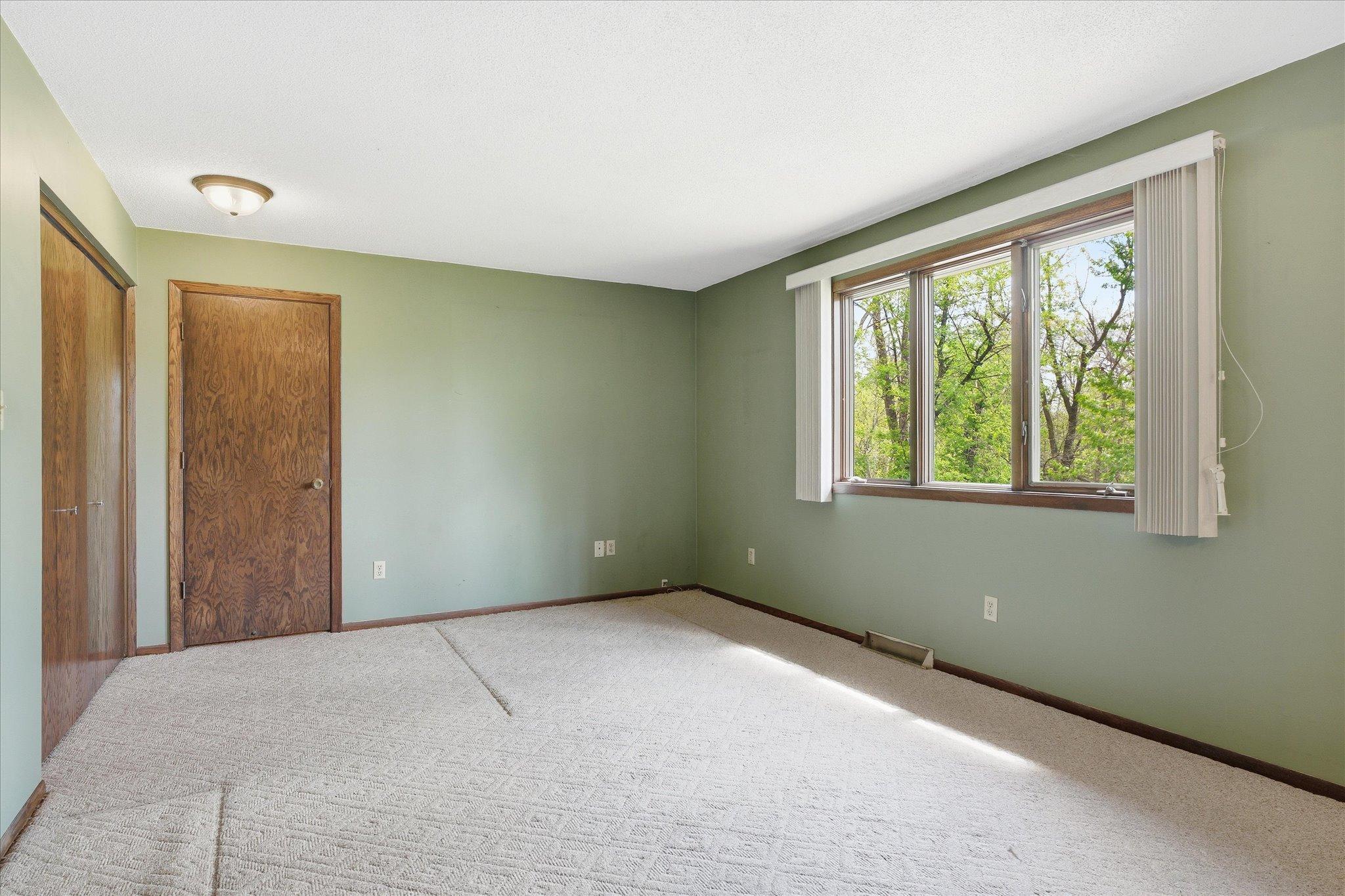 Another view of the primary bedroom. Large windows let in plenty of sunshine.
