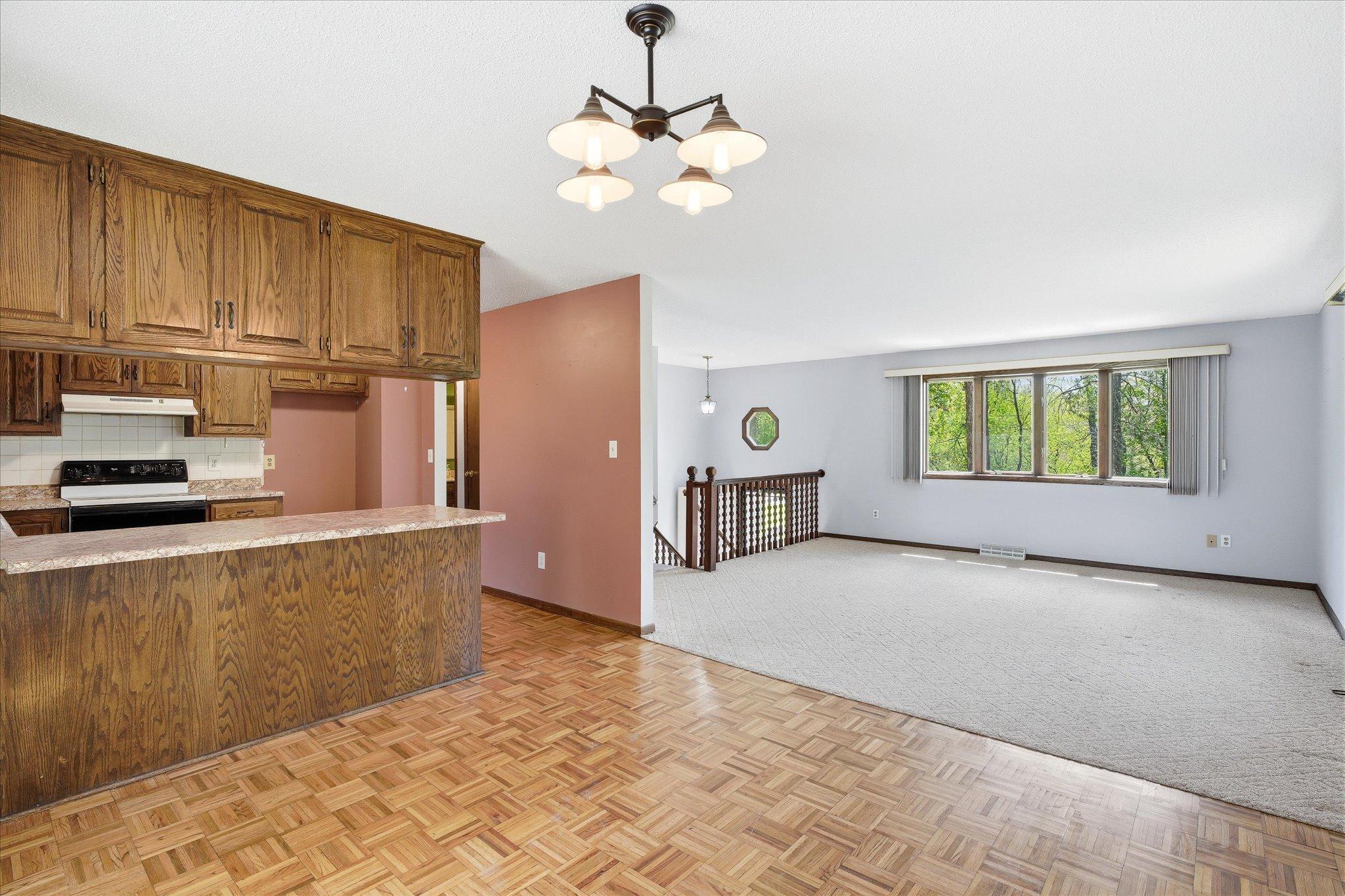 View of the living room area which opens to the dining room and kitchen area. Notice the hardwood flooring.