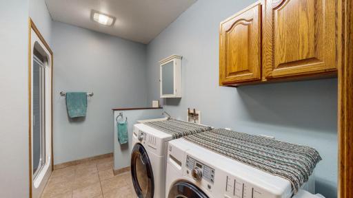 The second bathroom and laundry is shared both with a tasteful layout. Tiled flooring, cabinets, shower in back.