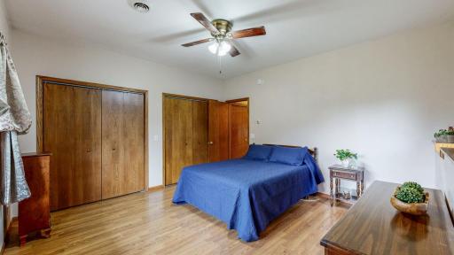 Main bedroom has two closets and laminated flooring