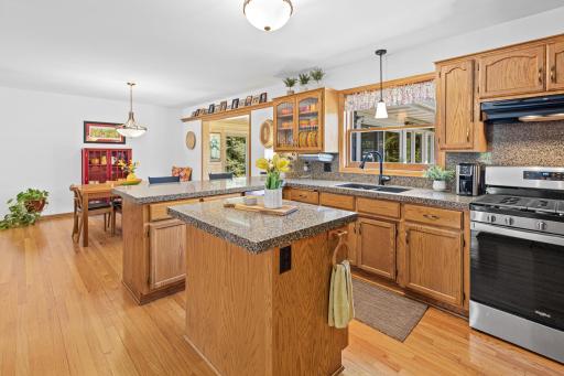 Beautifully designed kitchen overlooking the backyard with abundant cabinetry, generous prep space, and seamless flow to the dining area and four-season porch.