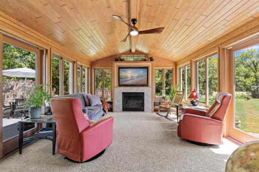Stunning four-season porch overlooking the flat backyard and pond views beyond.