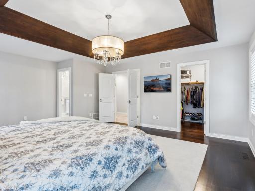 Doorway to the left leads to the primary bathroom and second closet, door in the middle leads to the hallway and other bedrooms in the upper level, door on the right is second walk in closet in the primary