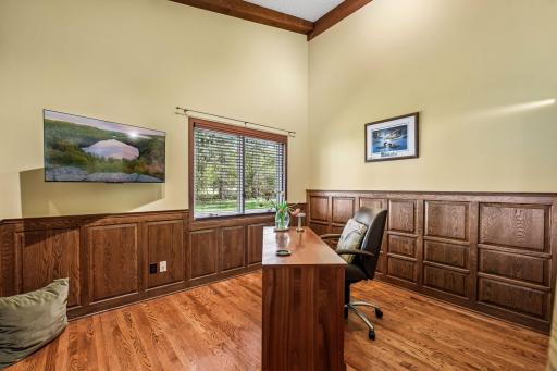 Office w custom woodworked walls and hardwood flooring. Vaulted ceiling w track lighting.