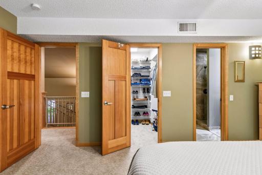 Partial view of deep walk in closet. Solid wood paneled doors.