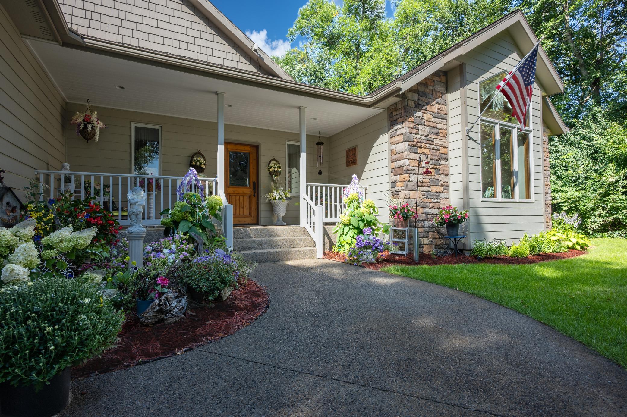 Covered front porch surrounded by beautiful Perennials and flowers.
