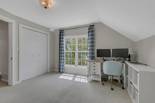 The spacious second bedroom offers fantastic flexibility! Currently styled as a home office, it features plush carpeting, a large closet, and a bright window that floods the space with natural light.