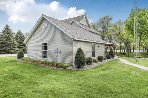 Move-in ready inside and out! This side view highlights the well-manicured green lawn and thoughtful, hassle-free rock landscaping that keeps the home looking sharp and tidy all year round.