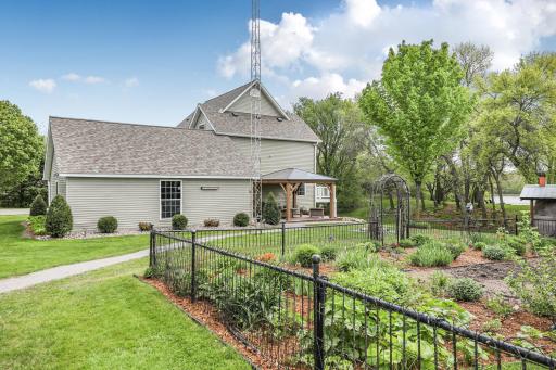 A beautifully manicured, fenced-in perennial flower garden adds exceptional charm and vibrant seasonal color to the backyard.