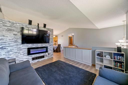 Vaulted ceilings and beautiful feature wall with electric fireplace and TV mount will stay. New floors and fresh paint