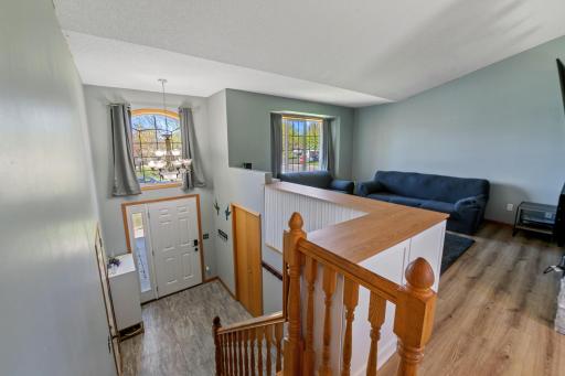 View of the foyer with new flooring and front door. Large windows make this home sunny and bright