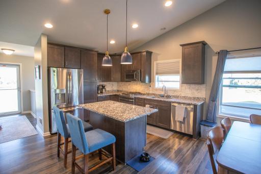 Kitchen with vaulted ceilings, stone counters and stainless appliances