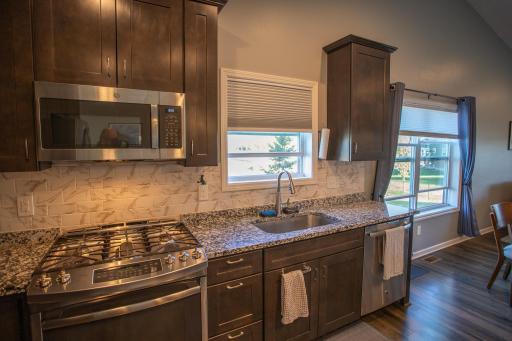 Kitchen with vaulted ceilings, stone counters and stainless appliances