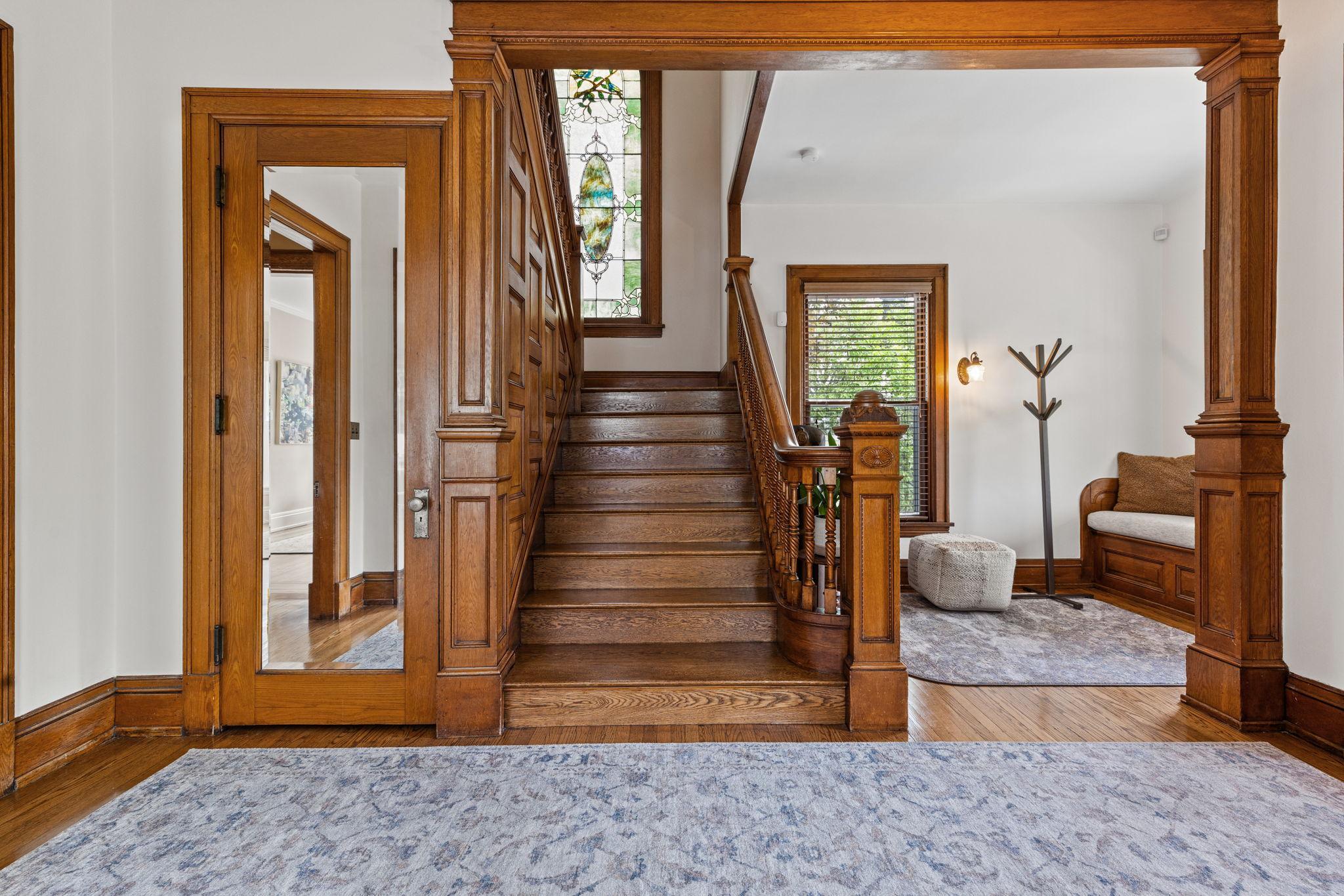 Grand oak staircase with amazing stained glass window.