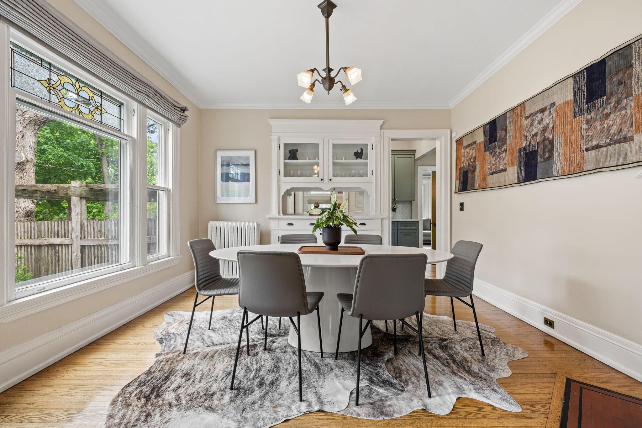 Lovely dining room with leaded glass picture window, built-in buffet, and decorative fireplace.