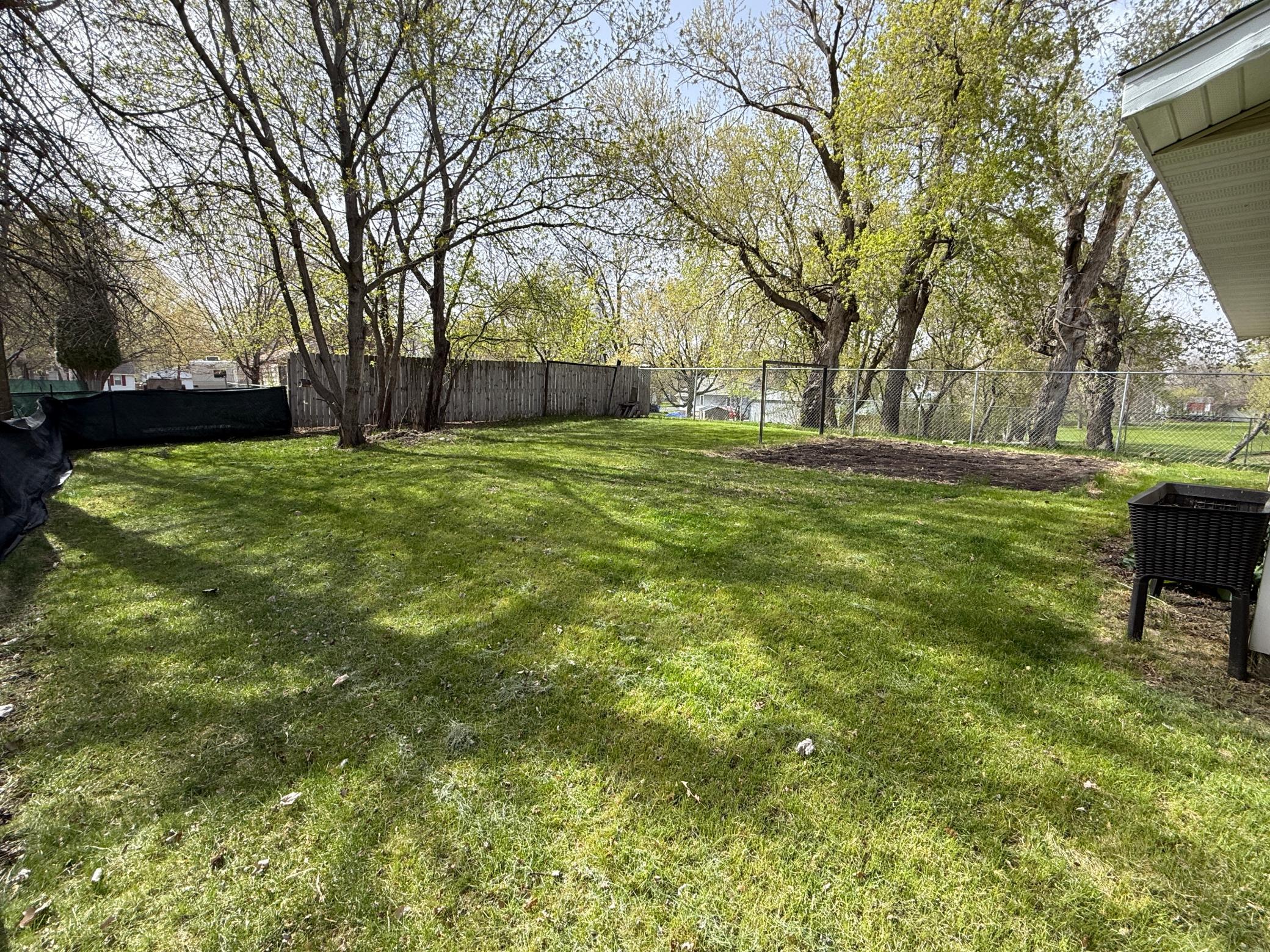 Yard with a garden and has tomatoes raspberries and rhubarb.