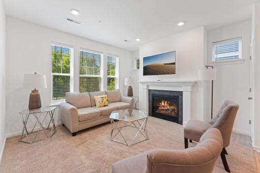 Main level living room with gas fireplace and tons of natural light and windows