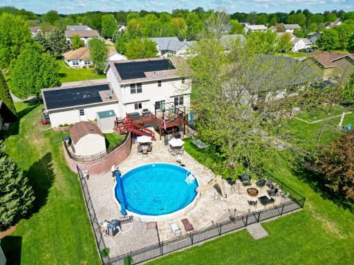 Step outside to your own resort-style retreat featuring an in-ground pool, waterfall feature, fire pit area, stamped concrete patio, and panoramic golf course views, an ideal setting for relaxing or entertaining.