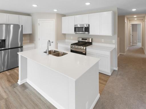 Kitchen. Photo taken of another home with similar plan and finishes. Photos and renderings may not depict actual plan, materials, & finishes may vary. All measurements are approximate.