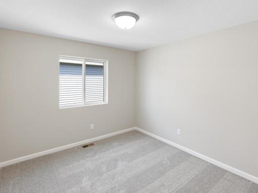Bedroom 2. Photo taken of another home with similar plan and finishes. Photos and renderings may not depict actual plan, materials, & finishes may vary. All measurements are approximate.