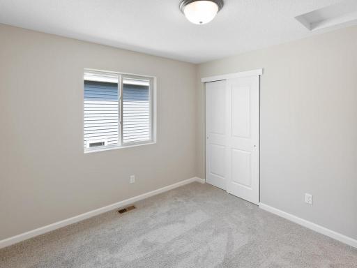 Bedroom 3. Photo taken of another home with similar plan and finishes. Photos and renderings may not depict actual plan, materials, & finishes may vary. All measurements are approximate.