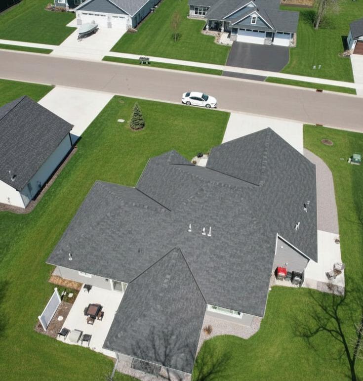 Bird’s-eye view of the home’s spacious concrete driveway, RV parking pad, and patio areas.