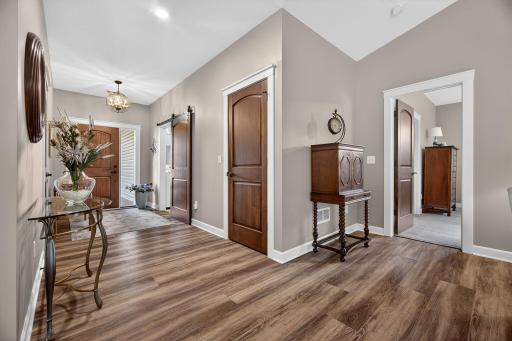 Bright, open foyer featuring solid wood doors and a custom barn door leading to the laundry roomâcombining warmth, character, and everyday functionality.