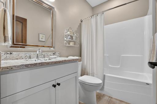 Second full bathroom featuring a granite-topped vanity.