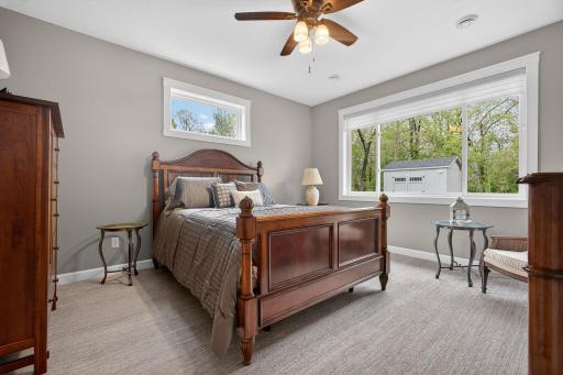 Spacious primary suite filled with natural light, featuring plush upgraded carpeting, a ceiling fan, and a generous walk-in closetâpaired with a luxurious spa-like ensuite for ultimate comfort.