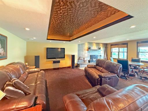 Comfortable family room featuring a built-in entertainment center and a tray ceiling with stylish tile detail and soft lighting.