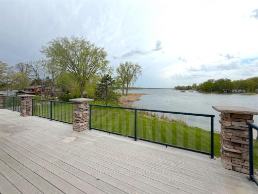 The maintenance-free deck is beautifully accented by stacked stone pillars, creating a warm and inviting outdoor space.