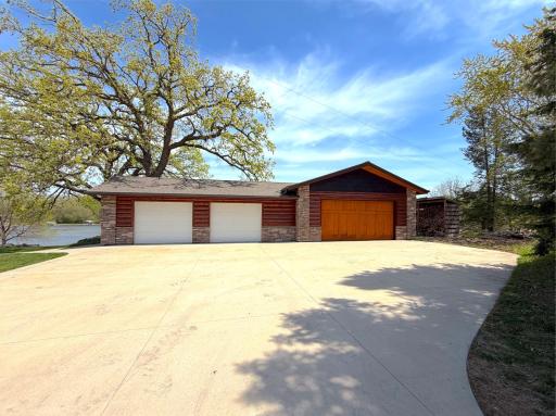 Half-log siding and stacked stone accents give the exterior a warm, rustic feel, while the insulated garage interior offers comfort with a ceiling fan and overhead lighting. Garage is heated and cool with LP gas forced air.