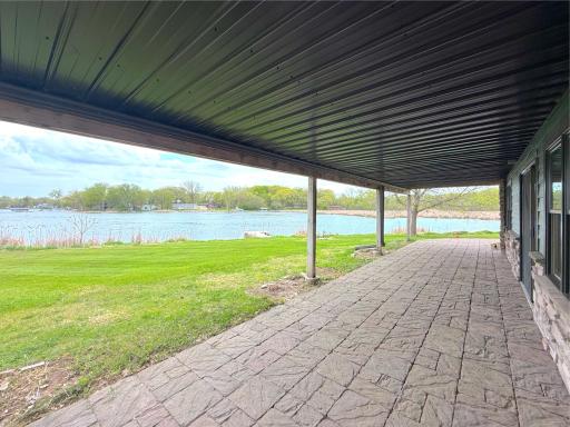 The covered patio invites you to enjoy sweeping views of the lake in comfort.