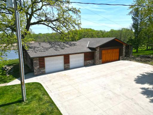 The property is equipped with a 4-stall insulated detached garage and an expansive concrete driveway, providing exceptional space for parking and storage needs.