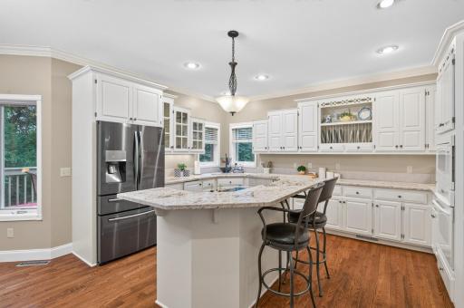 Double oven with separate cook-top in the island, stainless steele refrigerator. Detailed glass cabinetry doors, and open spaces to display your dishes